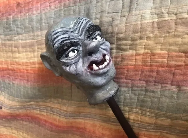 A close up of an old head on a stick