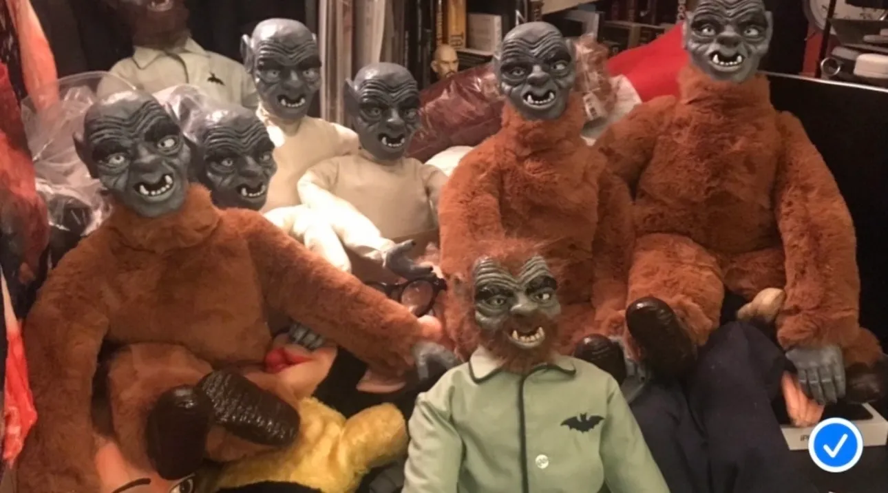 A group of stuffed monkeys and a man in green shirt.
